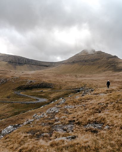 A beautiful vertical photo of a man against the background of a nature in Faroe Islands