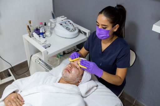 A closeup shot of a doctor wearing a purple mask and gloves treating her patient