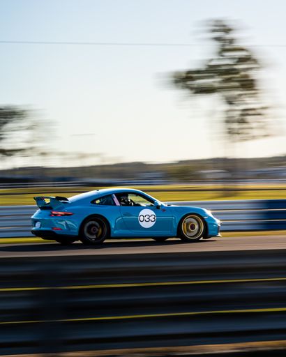 A blue Porsche 911 racing on the track in Sebring, United States