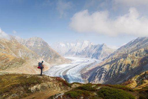 Automnal landscape view of a hiker contemplating the Aletsch glacier in Wallis Switzerland