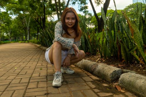 An attractive joyous lady from Vietnam posing for the camera at the park on a sunny day
