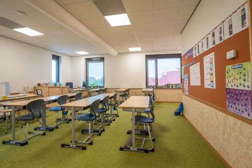 A classroom for primary school students with tables and chairs neatly lined up