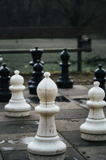 The chess pieces on a park floor, strategic game outdoors