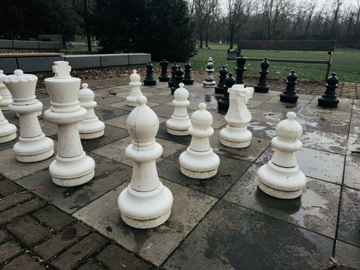 The chess pieces on a park floor, strategic game outdoors