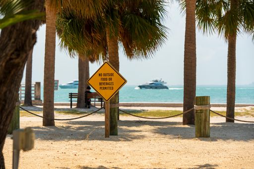 A sign that says No Outside Food or Beverages with a boat and the ocean in the background