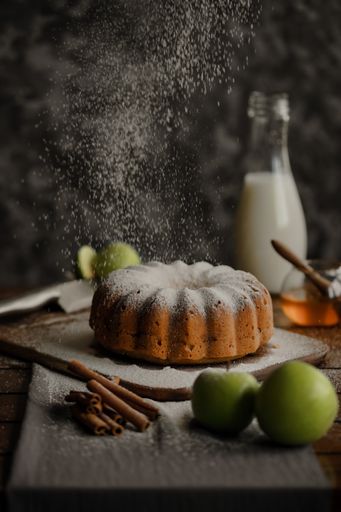 A vertical shot of apple bundt cake dusted with sugar powder