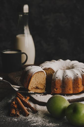 A vertical shot of apple bundt cake dusted with sugar powder
