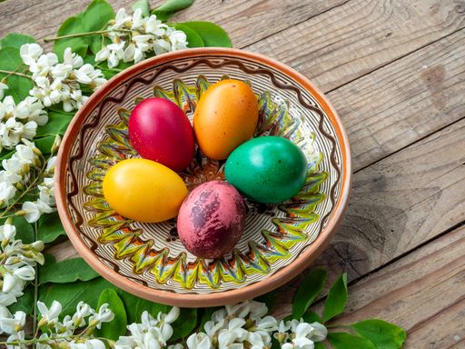 Basket filled with eggs and white flowers beside it