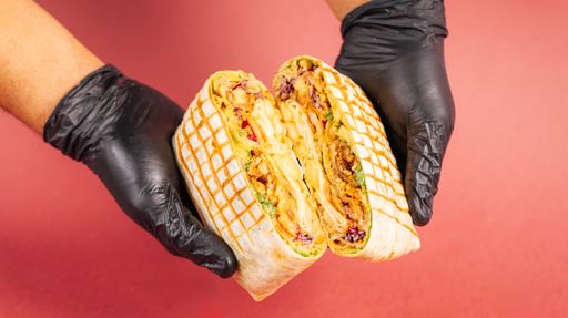 Black gloves holding up a traditional quesadilla with meat and tortilla