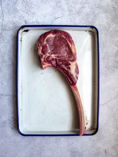 A vertical top view of an uncooked tomahawk steak cut