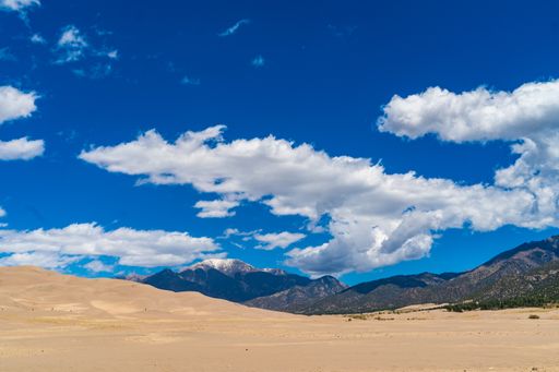 Scenic desert landscape at Great Sand Dunes National Park, Colorado, under a cloudy blue sky