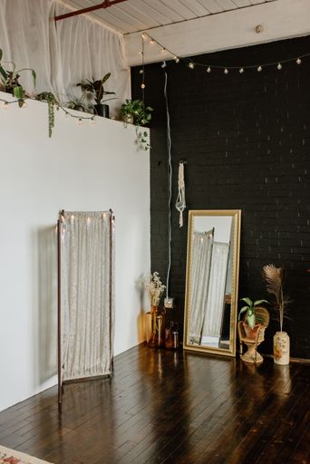 A bedroom adorned with abundant wall plants and a spacious mirror