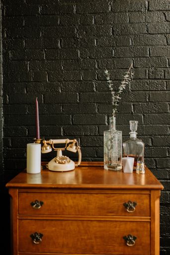 Table adorned with assorted vases, bottles, and a lamp