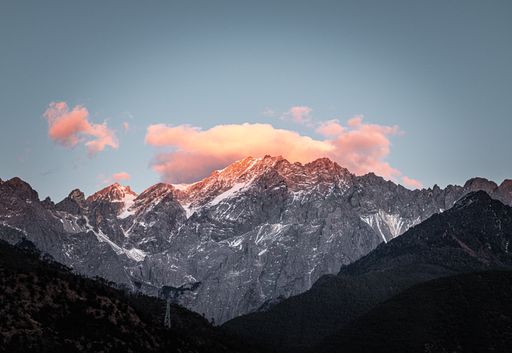 The sun setting behind snow-capped mountain