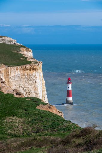 A lighthouse on a rugged cliff over the sea