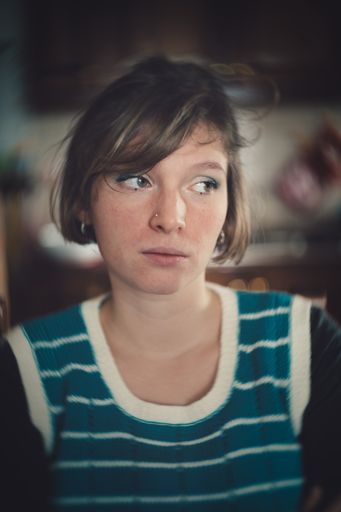 A portrait of an Italian woman with short hair and a piercing looking right