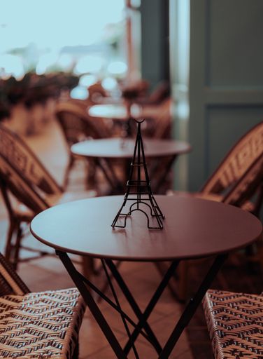A plastic tower miniature on a table at an outdoor cafe