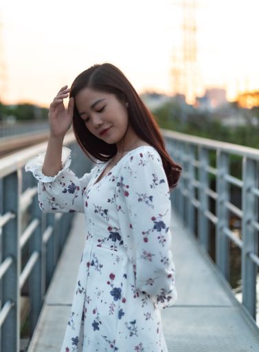 A black-haired Vietnamese girl looking down on a bridge
