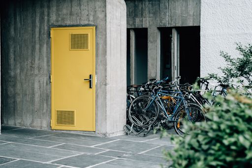 A view of a yellow door and bicycles parked near the entrance