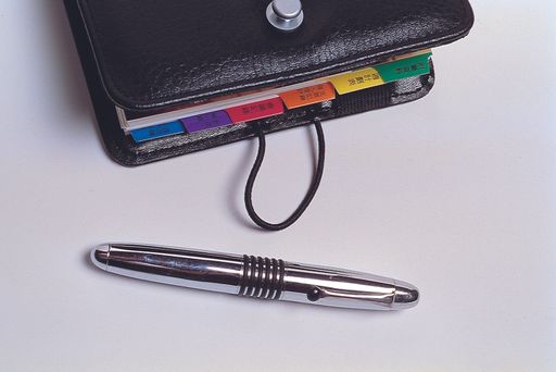 An overhead shot of a diary book and a ball pen on an isolated background
