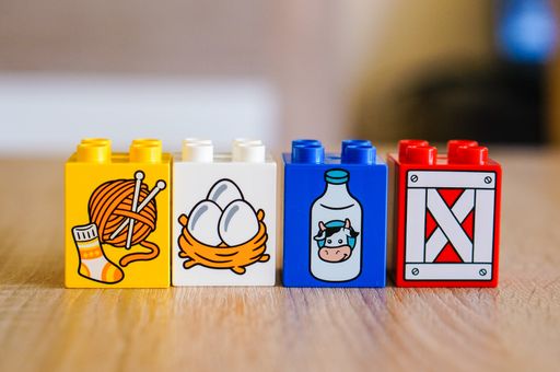 A selective closeup of the colorful plastic Lego Duplo toy blocks with illustrations on a table