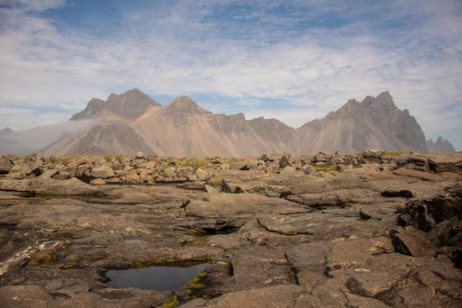 A closeup shot of a landscape with rocky field and cliffs in the background