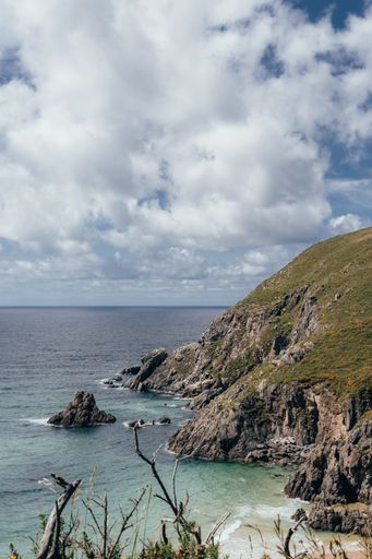 A beautiful view of the sea surrounded by cliffs under a cloudy sky in Galicia, Spain