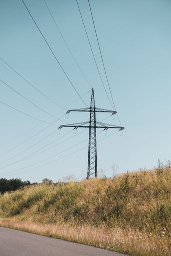 A vertical shot of a transmission tower in a rural area