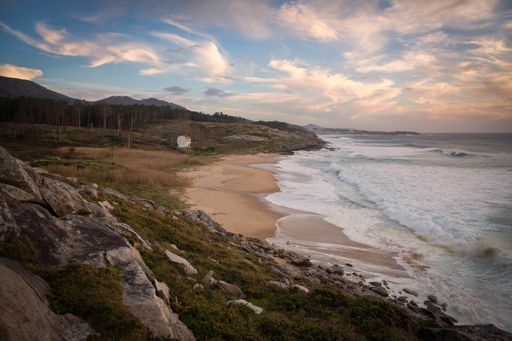 A beautiful shot of a seashore with scenery of sunset in a cloudy blue sky