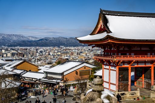 A Beautiful aerial view of Kyoto Japan with gate, pagoda, shops, and city covered in rare thick snow from the ancient sacred Kiyomizudera Temple.