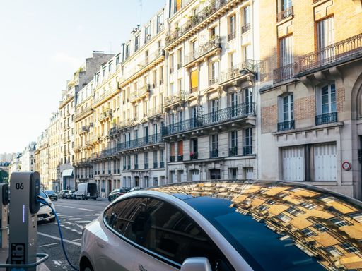An electric vehicle being charged on a Parisian street
