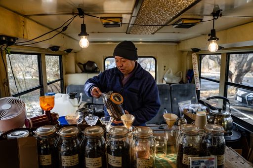Japanese man making pourover coffee in a converted school bus coffee shop. Winter time in Fuji Fujikawaguchiko Japan.