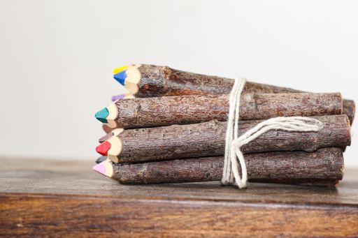 The vibrant wooden pencils tied with a ribbon on a wooden surface.
