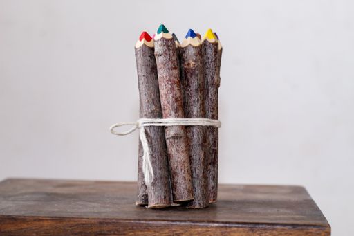 The vibrant wooden pencils tied with a ribbon on a wooden surface.