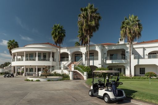 A golf cart outside a beachfront mansion