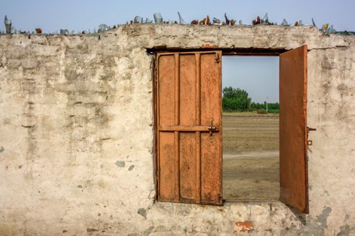 A closeup shot of an abandoned building with an open door