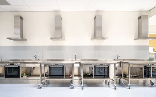 A modern industrial kitchen equipped with stainless steel appliances and workstations