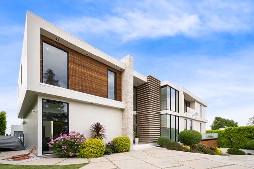 a Spacious contemporary house with lush greenery surrounding it