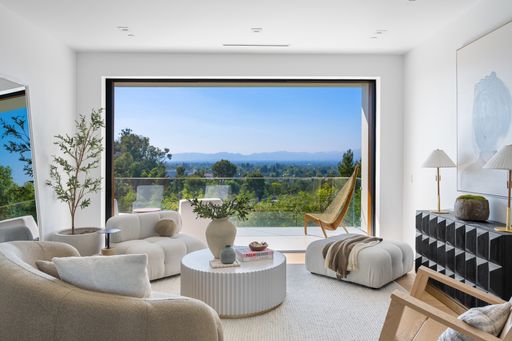 A Contemporary living room with wood details and a beautiful forest view