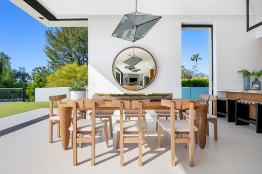 A Dining table with six chairs and circular mirror centerpiece