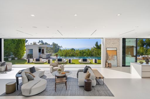 A well-furnished living room with a view of an outdoor pool and a patio