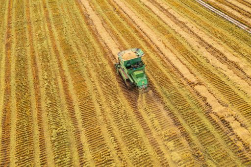 An aerial view of a green tractor in a field