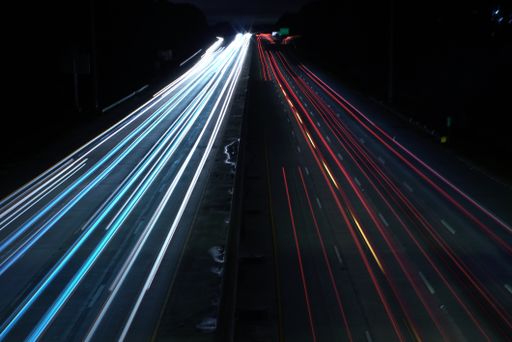 An overhead shot of a highway road with car light speed trails