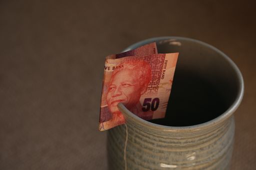 A closeup shot of a South-African banknote on a cup