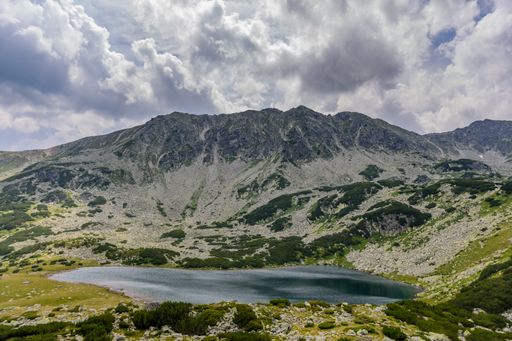 A serene lake nestled among rolling hills in Retezat National Park, Romania