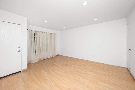 Bedroom with hardwood floor, ceiling lights, and bathroom door
