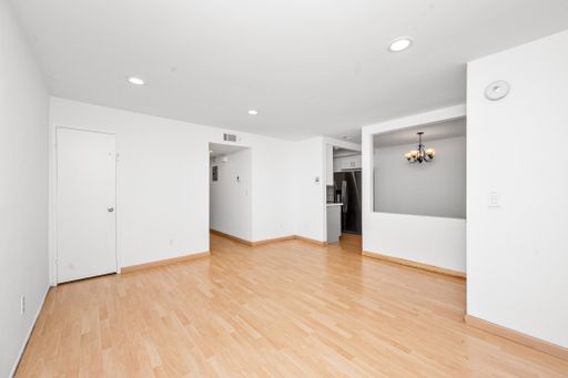 Empty room with white walls and light wooden floors