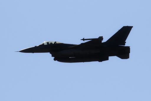 A military airplane flying in blue sky