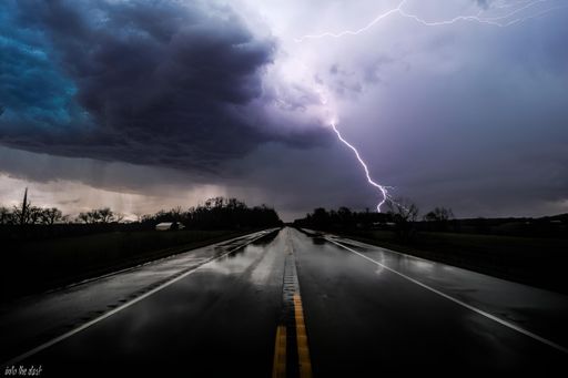 A lightning striking over a highway with one lane closed