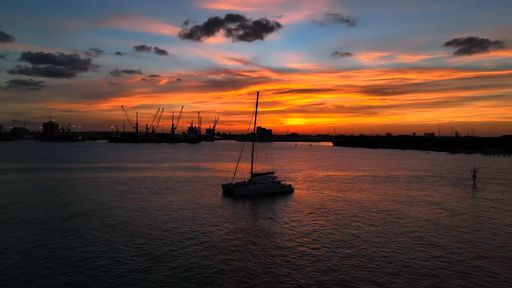 A sailboat sailing in the ocean at sunset